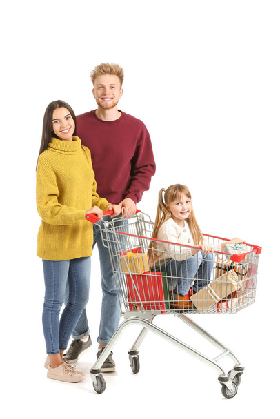 Family with shopping cart full of Christmas gifts on white background - Фото, зображення