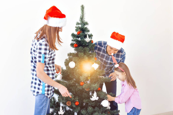 休日、 x-mas 、お祝いのコンセプト-白い背景に休日のクリスマスツリーを飾る幸せな家族 - 写真・画像