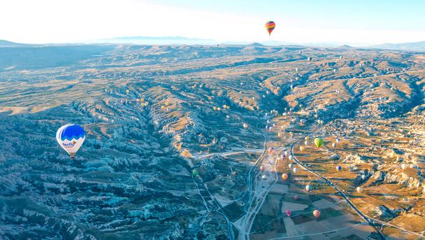 Vue aérienne du ballon aérien au-dessus des champs, Cappadoce, Turquie. Vue aérienne d'été depuis un ballon aérien au-dessus d'une route à Goreme, en Cappadoce, Turquie. Ballon aérien au-dessus des montagnes au lever du soleil, Cappadoce, Turquie
. - Photo, image