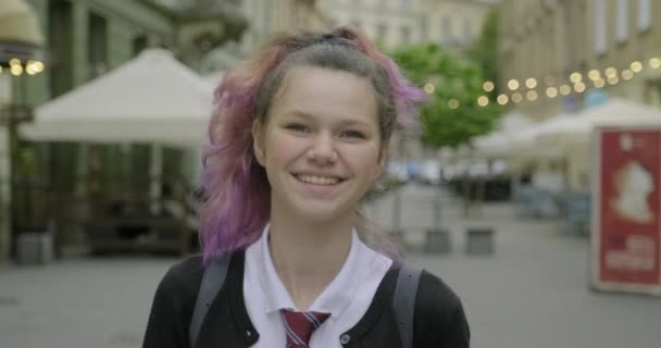 Teenager κορίτσι στο σχολείο στολή με σακίδιο με τα πόδια και χαμογελώντας - Πλάνα, βίντεο