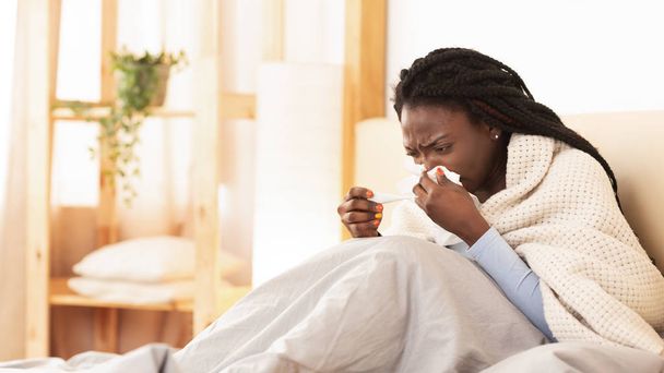 Malato afro donna che soffia Runny naso seduto a letto, Panorama
 - Foto, immagini