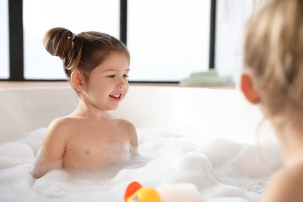 Cute little girl taking bubble bath at home - Fotografie, Obrázek