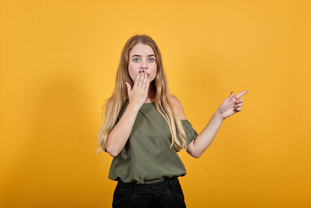 Young woman facial expression, covering mouth with hand, holding finger aside - Foto, Bild
