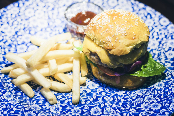 レストランでブループレート上のチキンハンバーガー、フライドポテトとソース - 写真・画像
