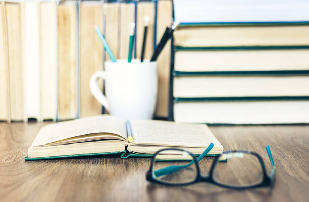 Stack of books, pencils, open book, glasses, background for educ - Photo, image