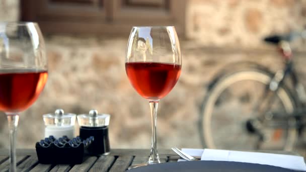 テーブルの上に赤ワインが２つワインがグラスの中で揺れている. - 映像、動画