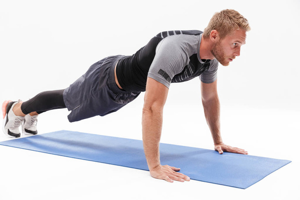 Confident attractive sportsman doing plank exercise - Fotoğraf, Görsel