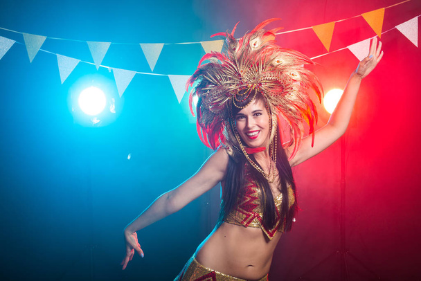 Karnevál, hastánc és üdülési koncepció-gyönyörű női Samba táncos visel arany jelmez-és mosolygós - Fotó, kép