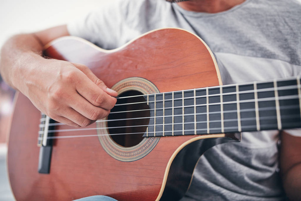 Man playing acoustic guitar in the living room. - Photo, Image