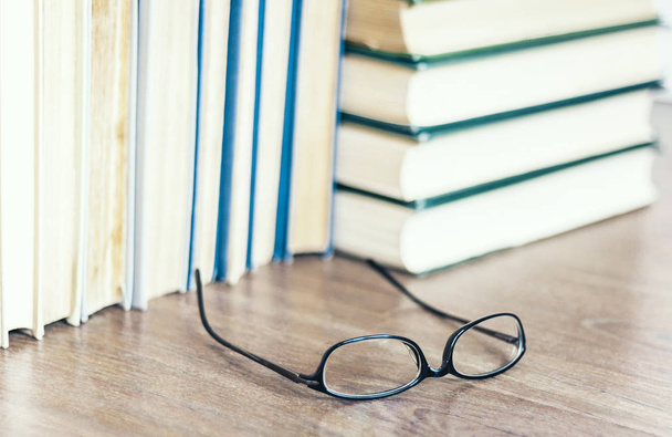 Stack of old book education concept background with glasses, man - Valokuva, kuva
