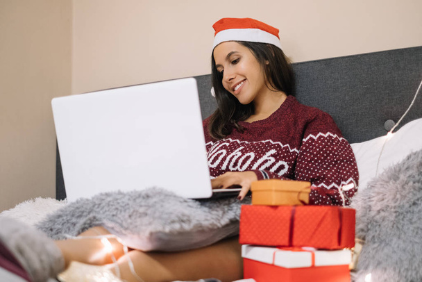 Close-up of woman with Santa hat using laptop - Фото, изображение