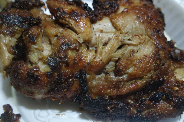 Крупным планом жареного цыпленка в белой тарелке, подаваемой на обед
 - Фото, изображение
