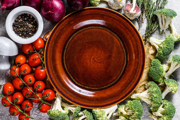 Top näkymä lautaselle keskuudessa kypsentämättömiä vihanneksia. Käsite kotiruokaa kasvisruokaa
 - Valokuva, kuva