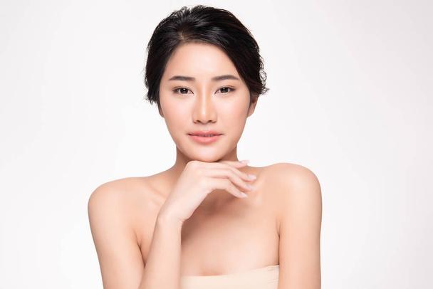 Kaunis nuori aasialainen nainen koskettaa pehmeää poskea ja hymyilee puhtaalla ja tuoreella iholla. Onnellisuus ja iloinen, valkoisella taustalla, kauneus ja kosmetiikka Concept
, - Valokuva, kuva