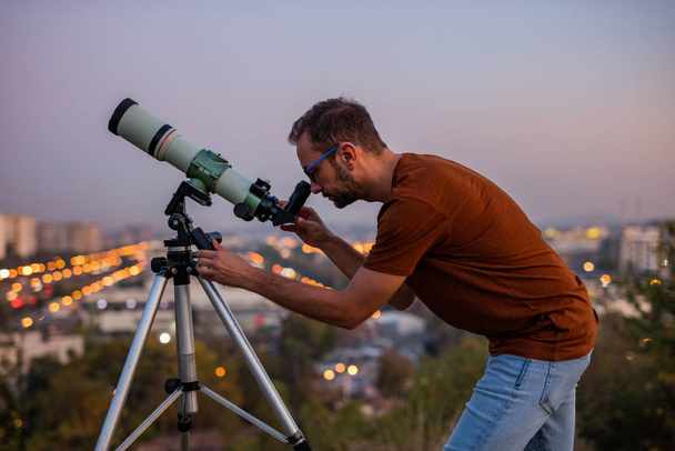 Astronomo con un telescopio che osserva le stelle e la Luna con
  - Foto, immagini
