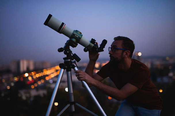 Tähtitieteilijä kaukoputkella katsomassa tähtiä ja Moon kanssa
  - Valokuva, kuva