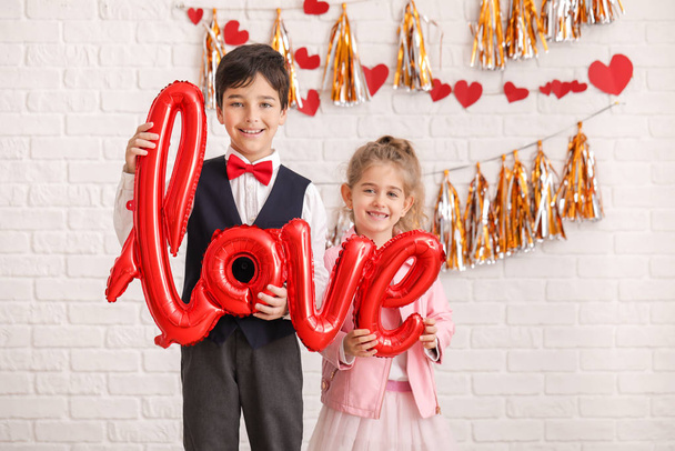 Cute little children with air balloon in shape of word LOVE indoors. Valentines Day celebration - Foto, Bild