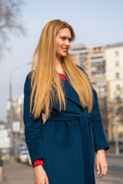 Young beautiful blonde woman in a blue coat - Foto, afbeelding