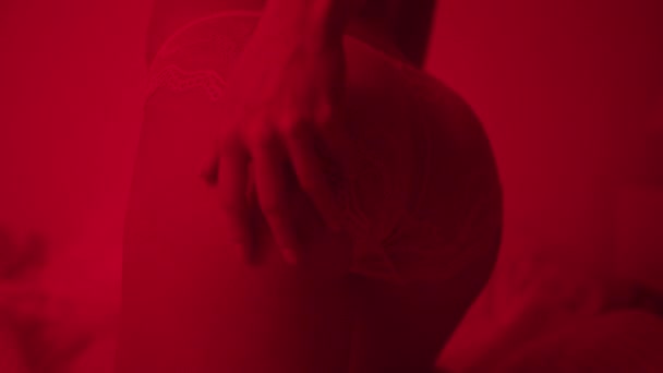 Szexi bugyis női fenék közelről. Szexuális lány pózol a sötét hálószobában. - Felvétel, videó
