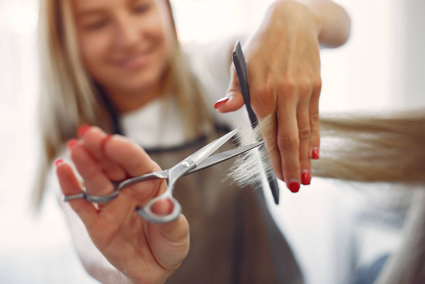 Hairdresser cut hair her client in a hair salon - 写真・画像