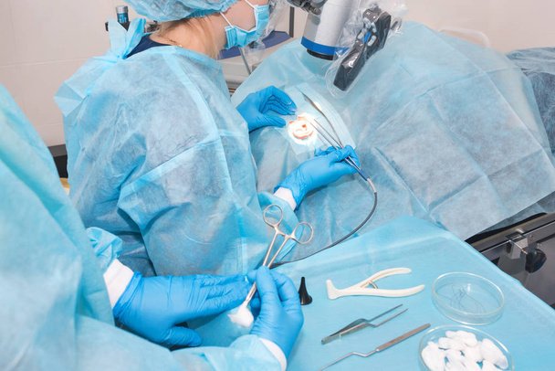 Nurse giving a tool to a doctor during surgery. Hands of doctors during hospital surgery. Ear surgery - Photo, Image