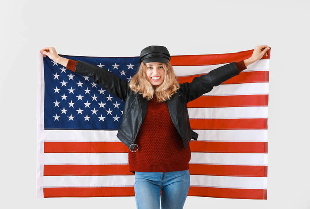 Young woman with USA flag on light background. Memorial Day celebration - Foto, immagini