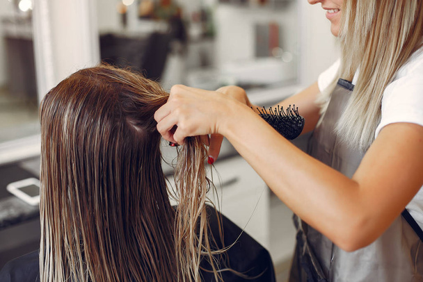 Woman drying hair in a hairsalon - 写真・画像