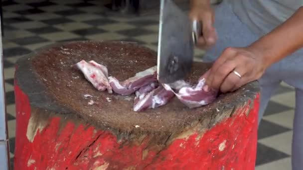 Muž seká sekáčkem čerstvé maso z berana. Člověk krájí kosti pro smažení - Záběry, video