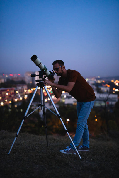 Астроном с телескопом наблюдает за звездами и Луной с
  - Фото, изображение