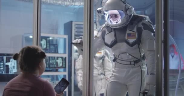 Astronauta dopasowanie dłoni z dziewczyną przed wyjazdem - Materiał filmowy, wideo