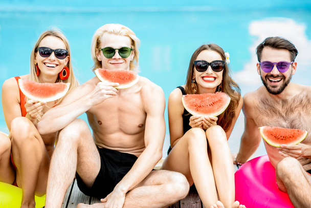 Amis avec pastèque sur la piscine en plein air
 - Photo, image