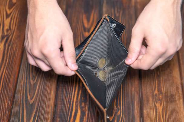 Close-up of a dark leather wallet. Purse with coins inside, focus on coins - Foto, afbeelding