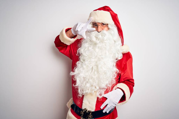Noel Baba kostümü giymiş orta yaşlı yakışıklı adam izole edilmiş beyaz arka planda duruyor. Barış sembolü yapıyor. Yüzünde parmaklar, yüzünde neşeyle zafer işareti yapıyor. - Fotoğraf, Görsel