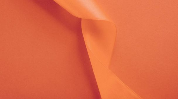 Abstraktní kudrnatá hedvábná stuha na oranžovém pozadí, exkluzivní luxus - Fotografie, Obrázek