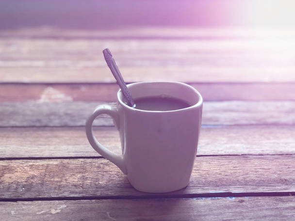 Nahaufnahme von schwarzem Tee in Tasse auf Holztisch - Foto, Bild