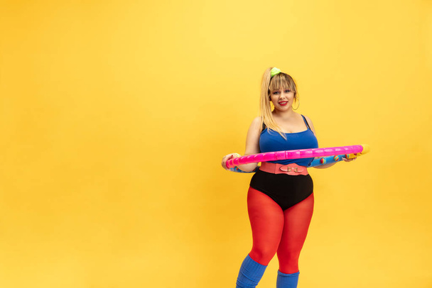 Young caucasian plus size female models training on yellow background - Foto, imagen