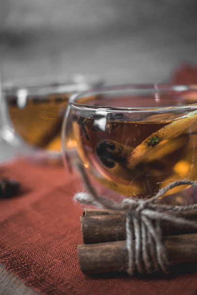 Apple Cider Drink, Juice, Punch, Tea with Spices, Cinnamon sticks, star anise and fresh Apples on a wooden background. Hot drink for Autumn and Winter evenings. Close up. Seasonal mulled drink. - 写真・画像