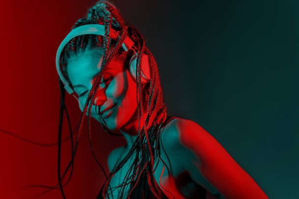 Dj woman with tree braid hair and dancing with headphones. - Foto, imagen