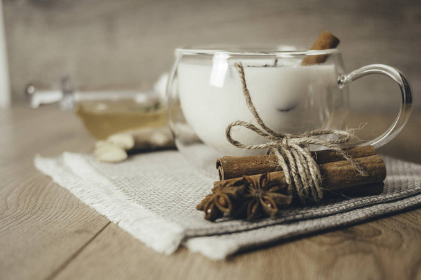 Γυάλινο φλιτζάνι παραδοσιακό ινδικό τσάι μασάλα. Ινδικό τσάι masala chai - καρυκεύματα τσάι με γάλα σε ρουστίκ ξύλινο φόντο, επιλεκτική εστίαση, αντίγραφο χώρου. Κλείσε..  - Φωτογραφία, εικόνα