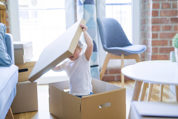 Beautiful toddler child girl playing with boxes at new home - Photo, Image