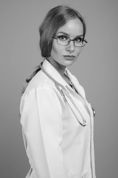 Νεαρή όμορφη γυναίκα γιατρός με ξανθά μαλλιά σε μαύρο και άσπρο - Φωτογραφία, εικόνα