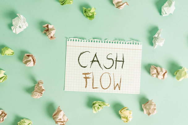 Woord schrijven tekst Cash Flow. Business concept voor het verkeer van het geld in en uit van invloed op de liquiditeit Gekleurde verkreukelde rechthoek vormige herinnering papier lichtblauwe achtergrond. - Foto, afbeelding