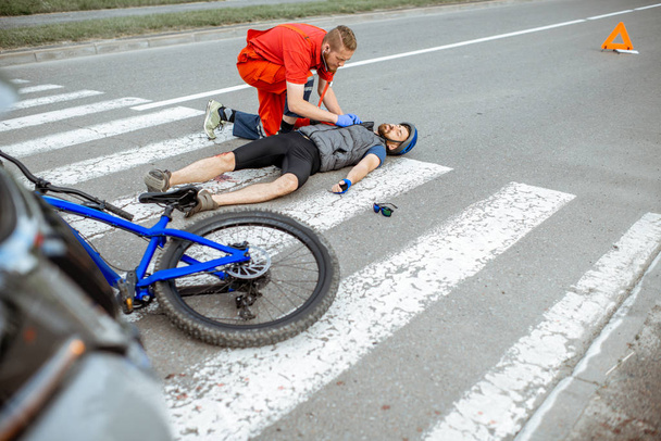 Γιατρός που εφαρμόζει τις πρώτες βοήθειες στον τραυματία στο δρόμο - Φωτογραφία, εικόνα