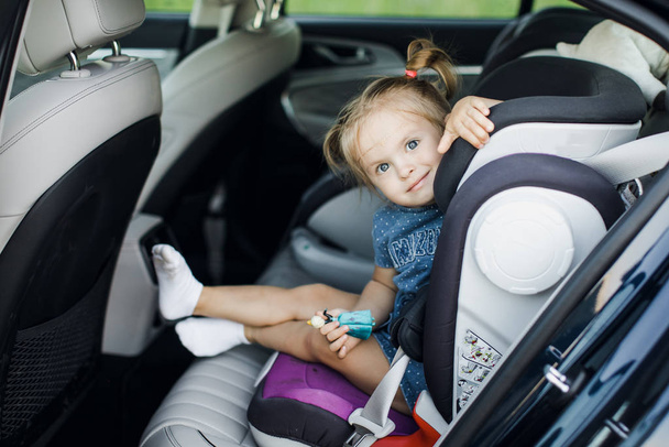 Mignon petit bébé assis sur le siège auto. Portrait de mignon petit bébé assis dans le siège d'auto. Concept de sécurité
. - Photo, image