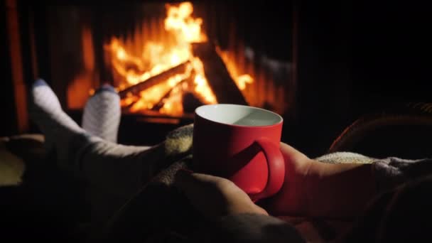 Frau mit roter Tasse Tee entspannt am Kamin - Filmmaterial, Video