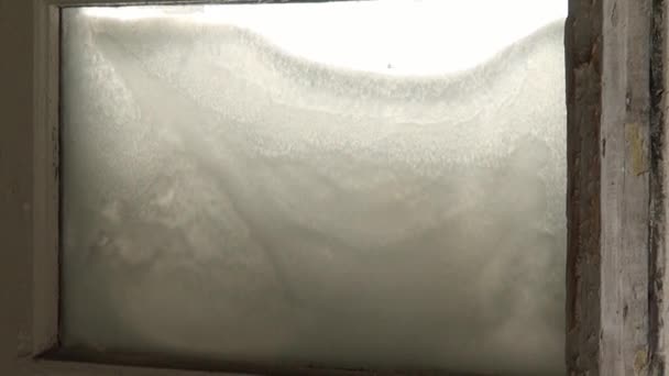 Lumi rikkinäisissä jäätyneissä ikkunoissa hylätyssä talossa autiossa kaupungissa
. - Materiaali, video