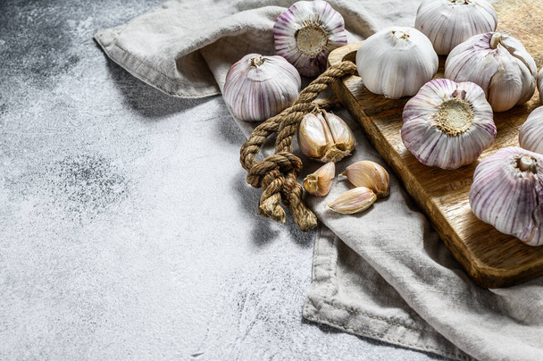 Garlic Bulb and garlic cloves on a wooden cutting Board. The concept of healthy eating. Gray background. Top view. Space for text - Φωτογραφία, εικόνα