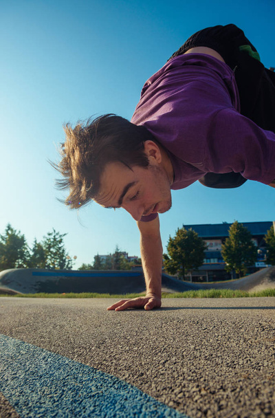 Молодой спортсмен делает паркур и атлетические трюки
 - Фото, изображение