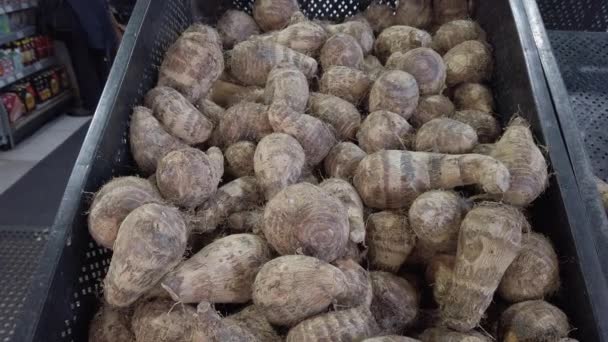 Zoom in on a pile of raw, unpeeled tropical Eddoes on a market stall in the UK - Video