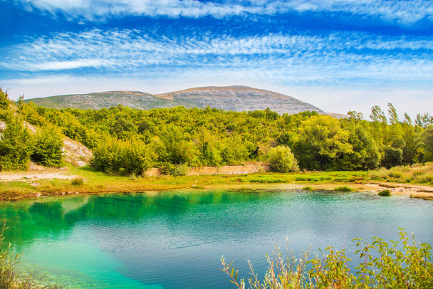 Croácia, Cetina rio fonte de água buraco e montanha Dinara no fundo, paisagem cárstica dálmata Zagora
 - Foto, Imagem